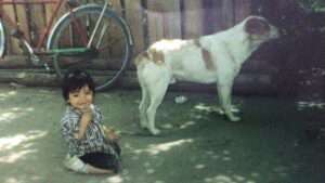 Young Oscar playing by a dog